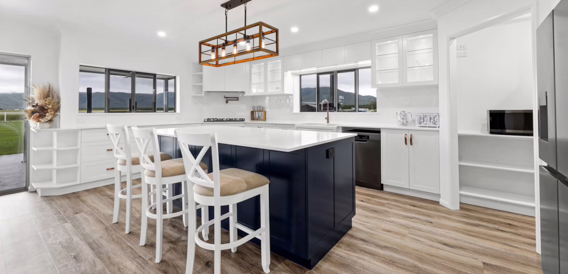 Open-plan navy and white kitchen with island seating by NV Builders Mackay
