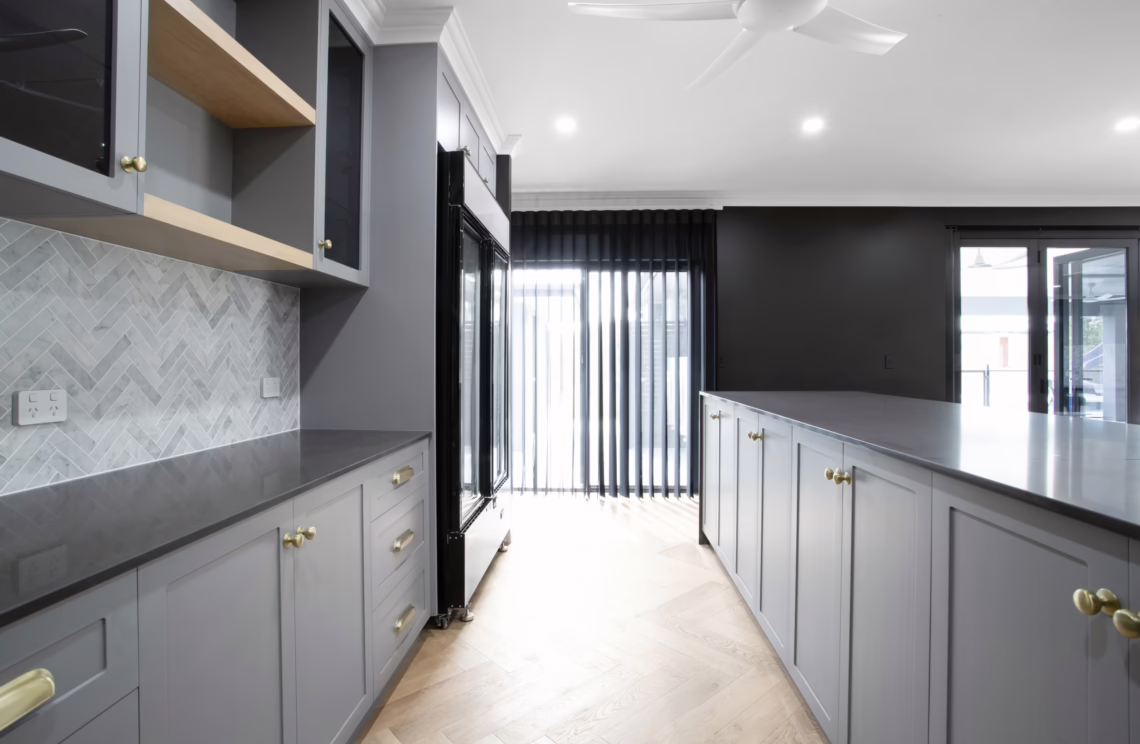 Modern grey kitchen with herringbone splashback and black accents by NV Builders Mackay